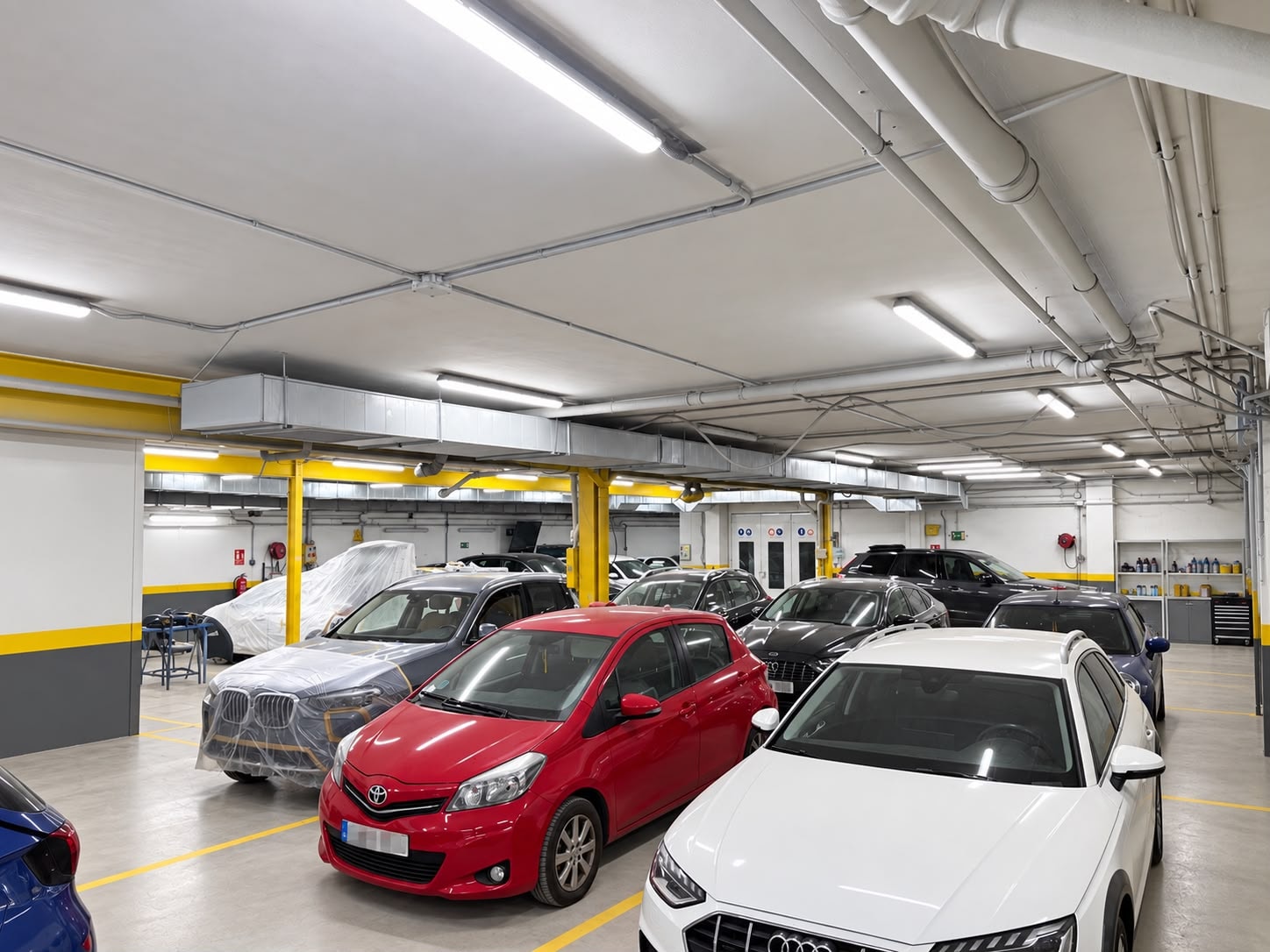 Zona de trabajo del taller Ecobox 360, con coches en reparación